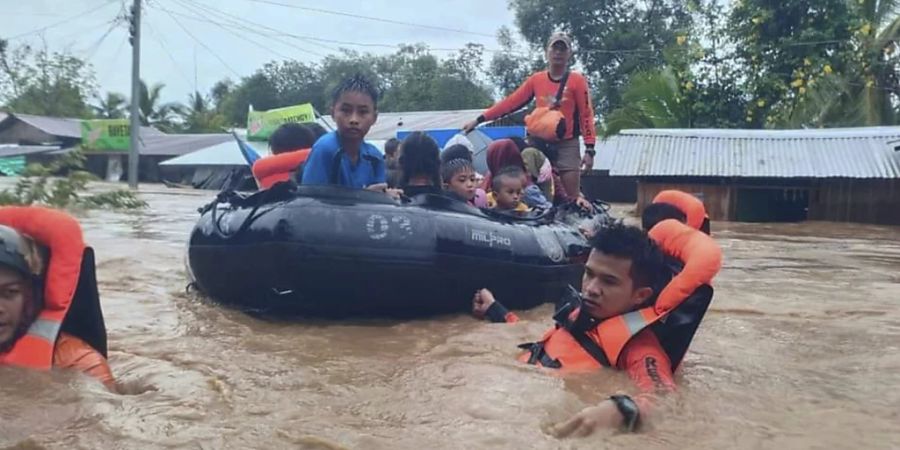 HANDOUT - Auf diesem von der philippinischen Küstenwache zur Verfügung gestellten Foto evakuieren Rettungskräfte Bewohner aus überschwemmten Gebieten infolge des Tropensturms Nalgae. Foto: Uncredited/Philippine Coast Guard/AP/dpa - ACHTUNG: Nur zur redaktionellen Verwendung und nur mit vollständiger Nennung des vorstehenden Credits