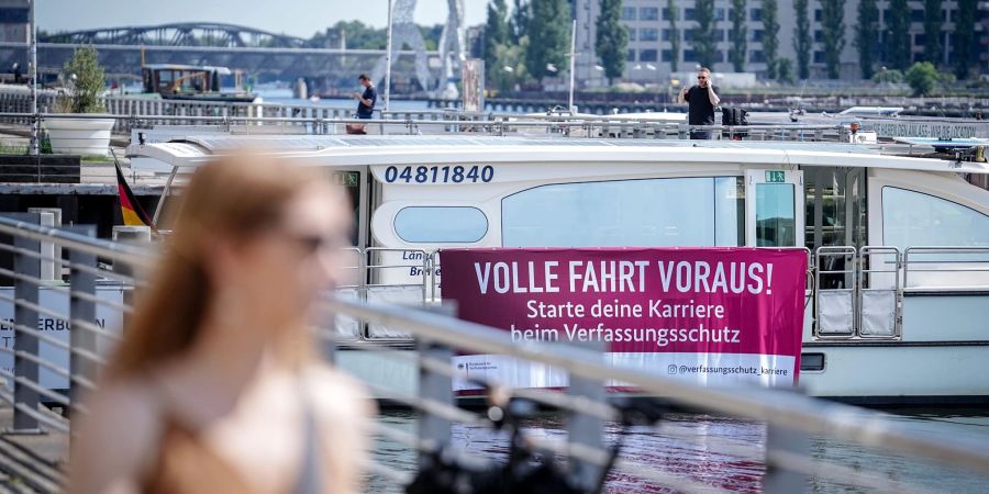 Mit einem Plakat an einem Solarschiff wirbt der nationale Nachrichtendienst für Nachwuchs.