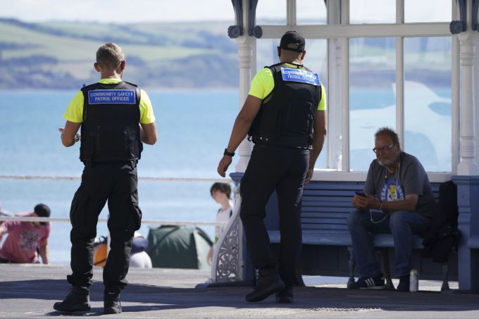 Beamte der kommunalen Sicherheitspolizei auf Streife in Weymouth, Dorset, als Asylbewerber im Hafen von Portland in Dorset, England, am Mittwoch, den 9. August 2023, auf dem Unterkunftsschiff Bibby Stockholm ankommen, das bis zu 500 Personen aufnehmen wird. Britain Migration