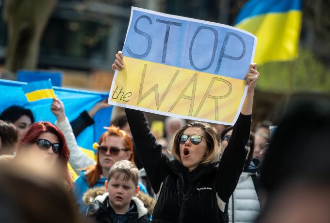 «Stop the war» steht auf dem Plakat einer Frau, die gegen eine zeitgleich stattfindende prorussische Kundgebung demonstriert. Prorussische Demonstration