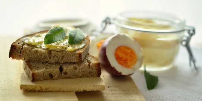 Brot und Ei darf man wieder zusammen verspeisen: die Trennkostthese, dass Eiweiss und Kohlenhydrate nicht zusammengehören, ist widerlegt. Brot Scheibe Ei gekocht Butter Holz