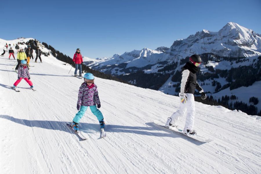 Skifahrer und Snowboarder im Skigebiet Adelboden-Lenk BE.