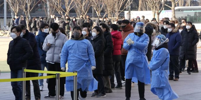 Medizinische Fachkräfte führen Menschen, die auf ihren Coronavirus-Test in einem behelfsmäßigen Testzentrum in Seoul, Südkorea, warten, Freitag, 18. Februar 2022. (AP Photo/Ahn Young-joon) South Korea Coronavirus