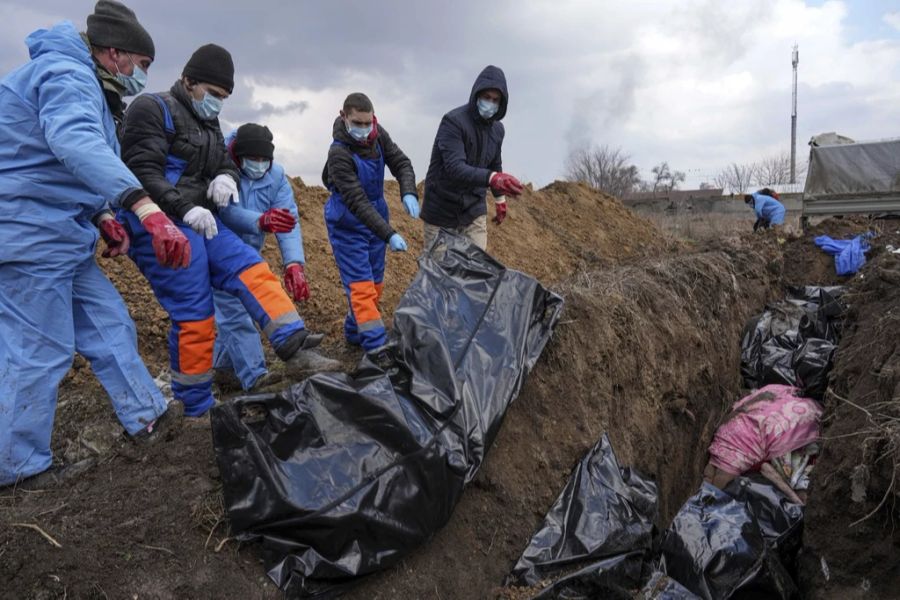 Tote werden im Ukraine-Krieg in ein Massengrab am Rande der ukrainischen Stadt Mariupol gelegt, da die Menschen ihre Toten wegen des schweren Beschusses durch die russischen Streitkräfte nic