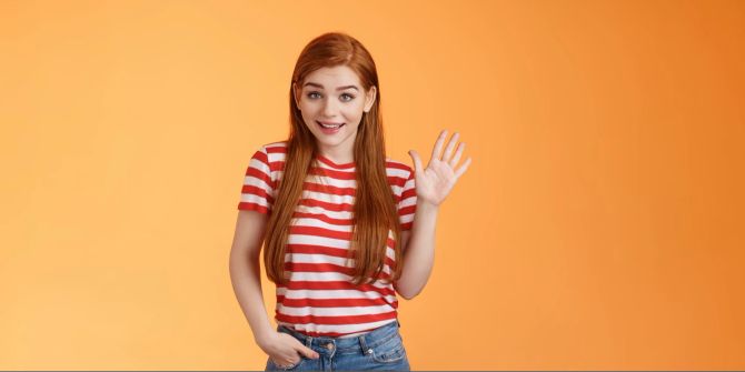 Mädchen winkt lächelnd.