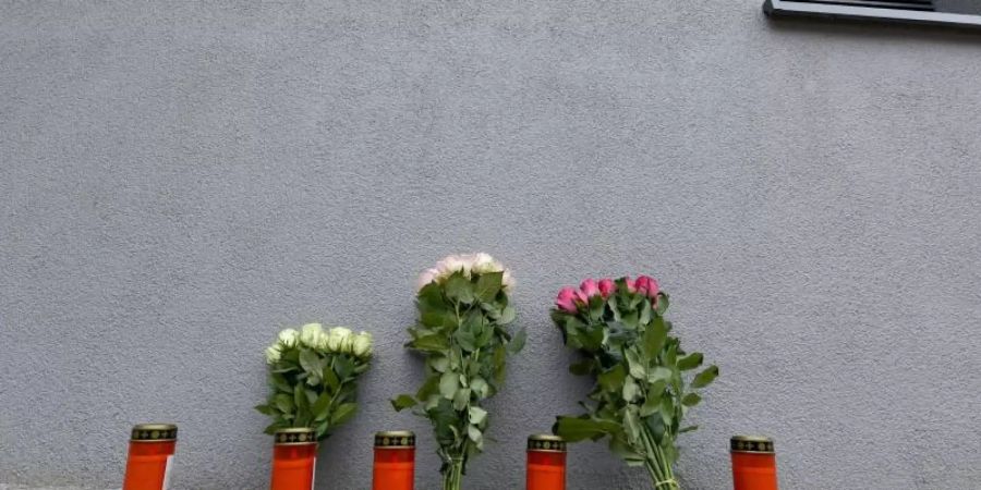 März 2018: Blumen und Grablichter vor dem Mehrfamilienhaus in Flensburg, in dem die 17-Jährige starb. Foto: Carsten Rehder