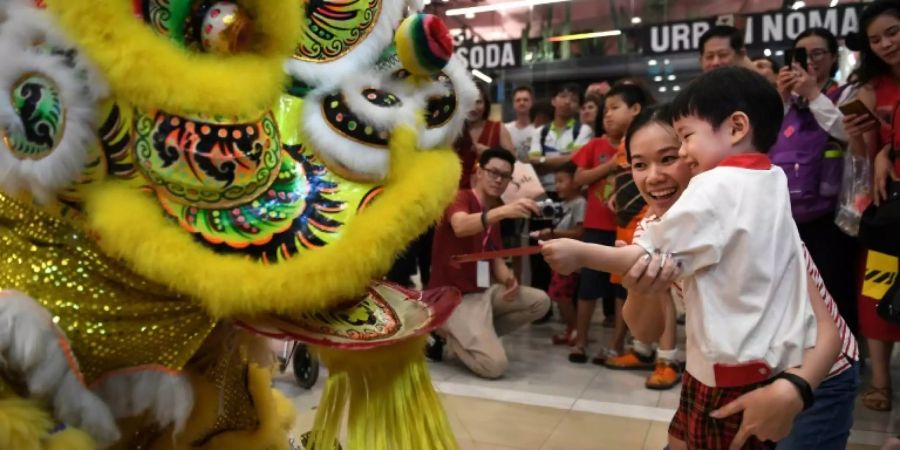 Ein Junge übergibt einem Tänzer einen Geldumschlag in Bangkok