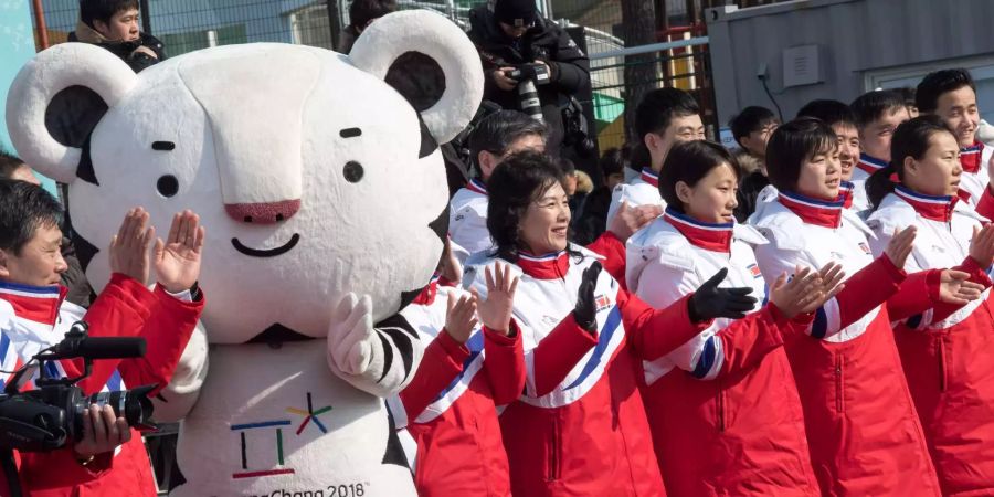 Nordkoreanische Athleten und Funktionäre neben dem Maskottchen Soohorang.