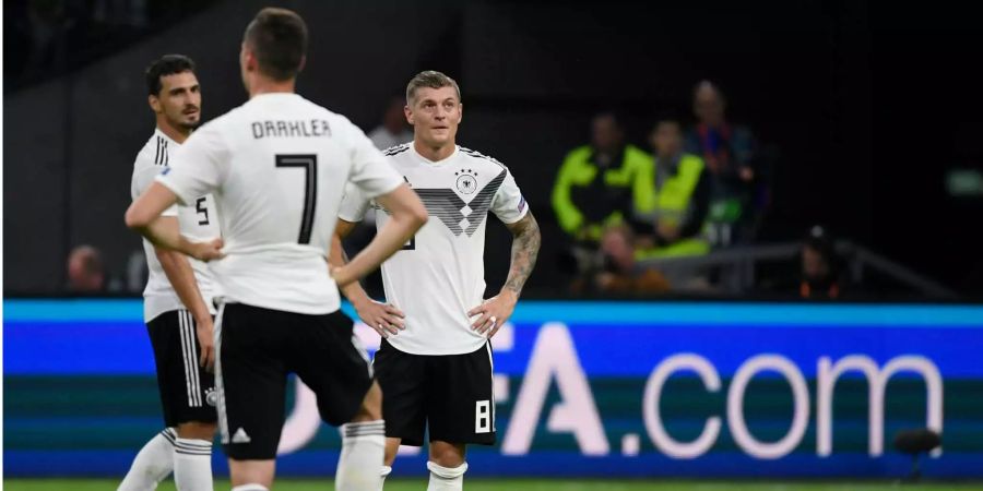 Mats Hummels (l-r), Julian Draxler und Toni Kroos aus Deutschland stehen nach der 0:3-Niederlage gegen die Niederlande enttäuscht auf dem Platz.