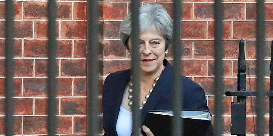 Theresa May verlässt ein Gebäude um eine Stellungnahme zu geben.