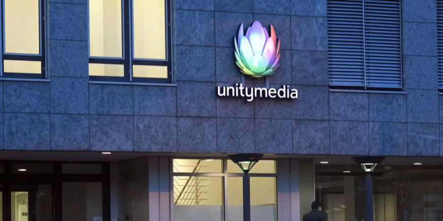 Ein Firmenschild hängt am Gebäude mit der Firmenzentrale des Unternehmens Unitymedia.