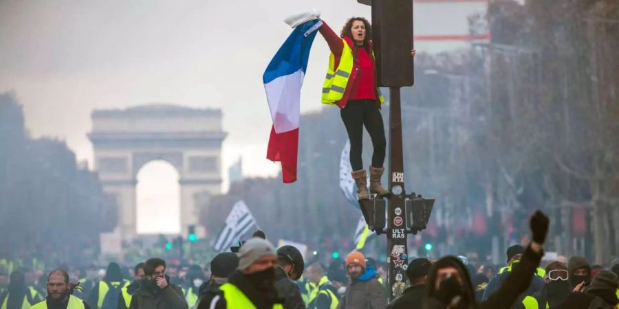 Eine Demonstrantin hält eine Frankreich-Flagge in der Hand.