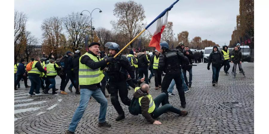 Demonstranten und Polizisten treffen auf der Champs-Elysees-Allee gewaltsam aufeinander.