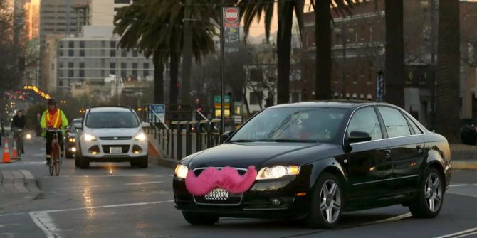 Ein Lyft-Auto, mit dem pinken Schnauzer über dem Nummernschild, fährt über die Market Street in San Francisco, Kalifornien (USA).