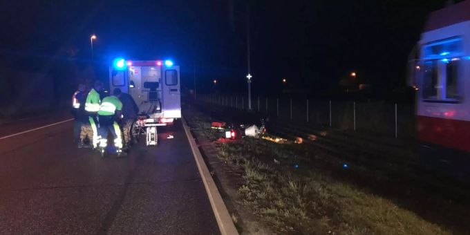 Verunfalltes weisses Motorrad neben der Strasse und Krankenwagen mit Rettungskräften davor - zvg Polizei Basel-Landschaft