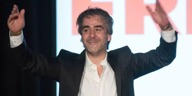 Deniz Yücel mit gehobenen Armen.