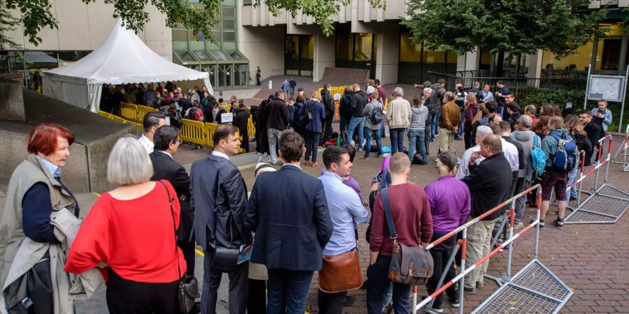 Zahlreiche Zuschauer stehen vor dem Gericht Schlange.