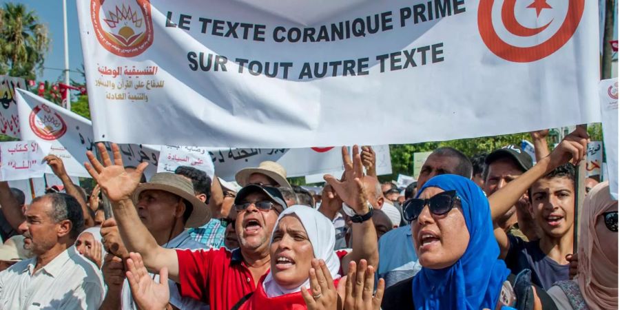 Demonstranten stehen vor einem Banner mit der Aufschrift «Der Text des Korans vor jedem anderen Text» um gegen die Massnahmen der Regierung zur Stärkung von Frauen- und Schwulenrechten zu protestieren.