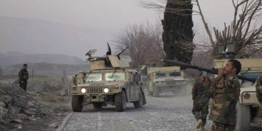 Mitglieder der afghanischen Sicherheitskräfte stehen am Ort eines Anschlages mit einer Autobombe nahe Nangarhar. Foto: Saifurahman Safi/Xinhua/dpa