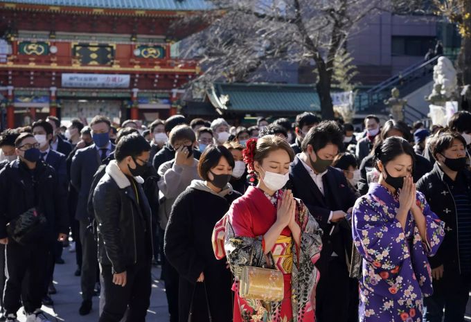 In Kimonos gekleidete junge Frauen sprechen Gebete für Wohlstand für ihre Unternehmen und die Wirtschaft während des Beginns des neuen Jahres am Kanda Myojin Schrein in Tokio, Japan, 04. Januar 2021. Tokyo Japan