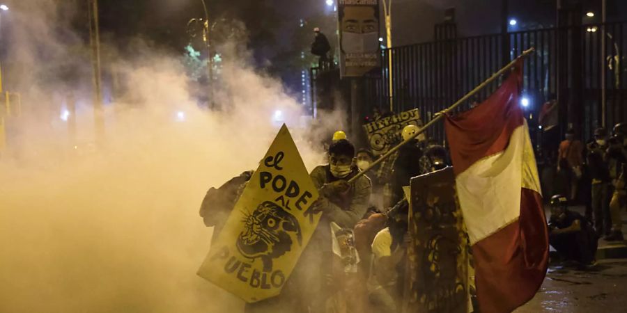 Demonstranten flüchten vor Tränengas, das von der Polizei eingesetzt wurde, um Demonstranten zu zerstreuen, die sich auf der Plaza San Martin versammelten, um gegen die Amtsenthebung des Ex-Präsidenten Vizcarra zu demonstrieren. Zum sechsten Tag in Folge hat es in Peru Demonstrationen gegen die Amtsenthebung des Ex-Präsidenten Vizcarra gegeben. Foto: Rodrigo Abd/AP/dpa