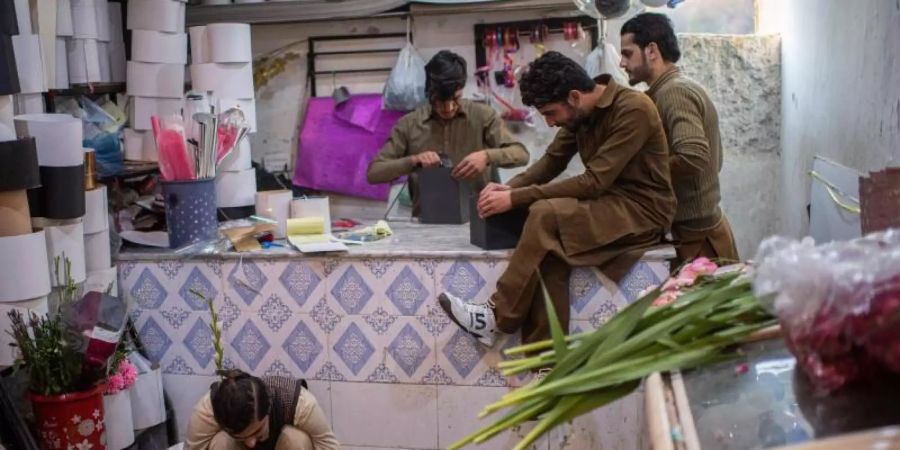 Junge Männer in Islamabad bereiten Blumengeschenke für den Valentinstag vor. Foto: Arne Bänsch/dpa