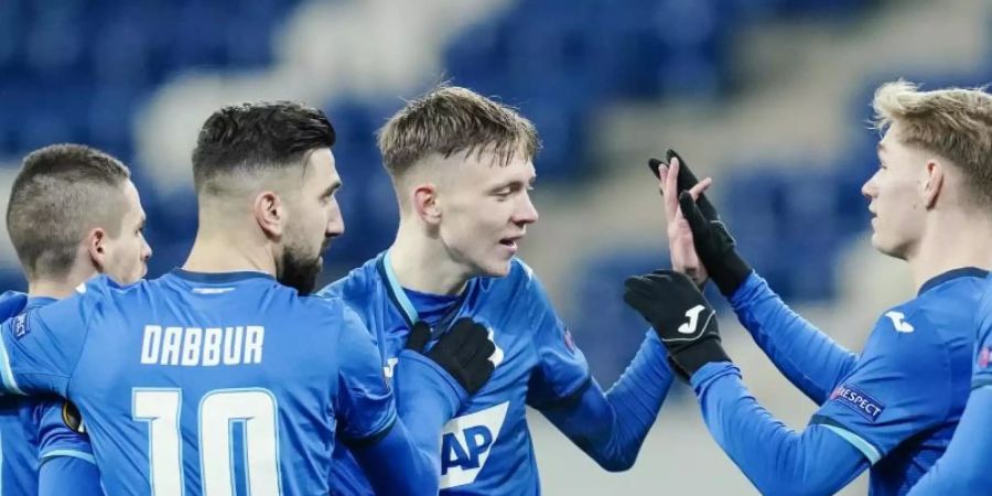 Hoffenheims Torschütze Maximilian Beier (M) jubelt mit seinen Mannschaftskollegen über das Tor zum 3:0. Foto: Uwe Anspach/dpa
