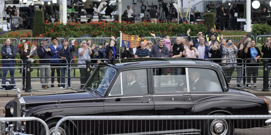 Menschen winken dem neuen König Charles in der Nähe des Buckingham Palastes.