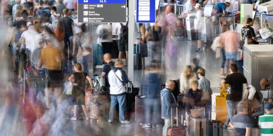 Tausende Passagiere warten vor den Abfertigungsschaltern des Flughafens auf ihren Check-In.