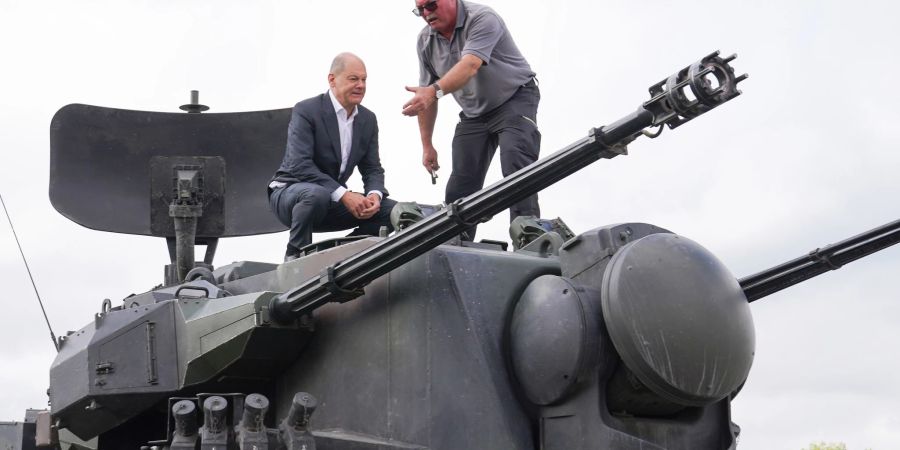 Bundeskanzler Olaf Scholz (l) besucht das Ausbildungsprogramm für ukrainische Soldaten am Flugabwehrkanonenpanzer Gepard. Neben ihm steht Jürgen Schoch, Ausbildungsleiter bei KMW.