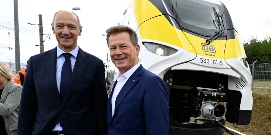 Roland Busch (l), Vorstandsvorsitzender von Siemens, und Richard Lutz, Vorstandsvorsitzender der Deutschen Bahn, stehen vor einem neuartigen Wasserstoffzug.