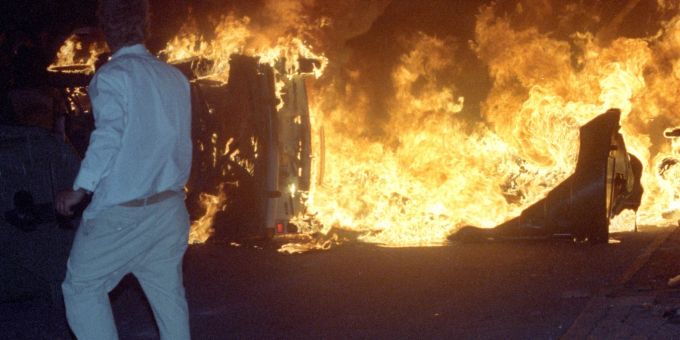Ein Mann steht 1992 bei den Ausschreitungen in Rostock-Lichtenhagen. (Archivbild) ausschreitungen in rostock-lichtenhagen