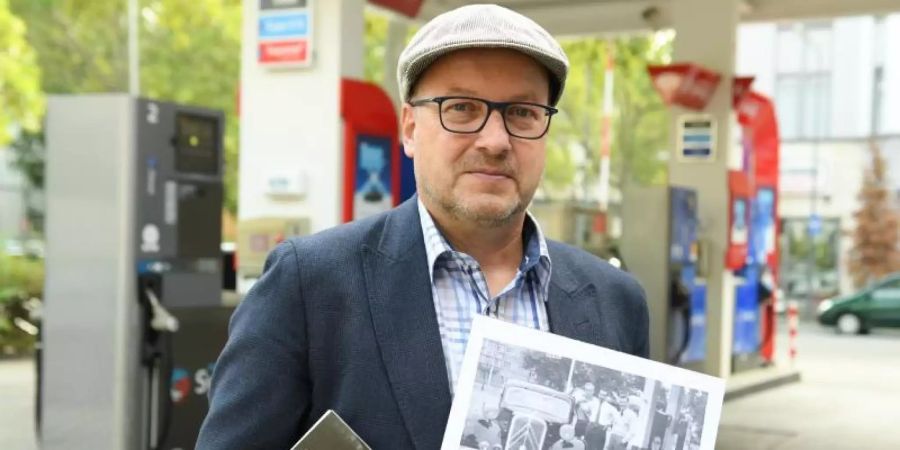 Jakob Stein mit seinem Roman «Der Gröschaz» und der Reproduktion eines Fotos mit Mitgliedern der Jägerbande in Frankfurt. Foto: Arne Detert