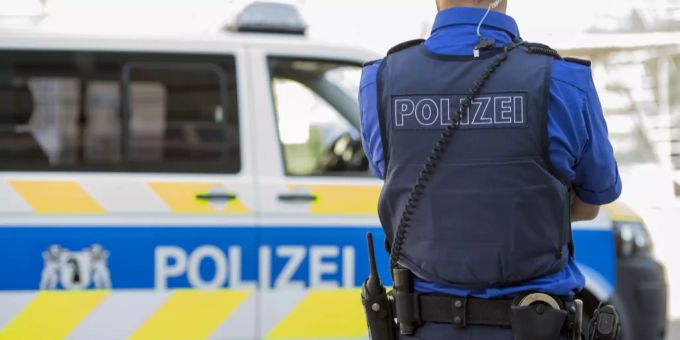 Ein Beamter der Kantonspolizei Basel-Stadt posiert in Uniform vor einem Einsatzwagen (Symbolbild). Passanten Messer