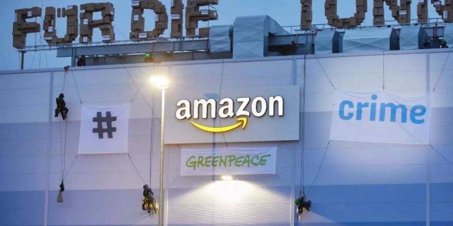 Greenpeace-Aktivisten hängen am Gebäude der Amazon-Logistik Winsen Transparente auf. Foto: Georg Wendt