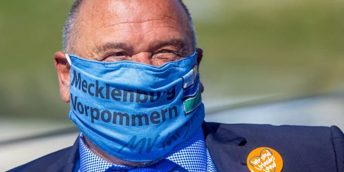 Harry Glawe (CDU), der Wirtschafts- und Tourismusminister von Mecklenburg-Vorpommern, steht mit einem Mundschutz bei der Enthüllung eines rund 40 mal 40 Meter grossen Plakats am Hotel Neptun. Tourismus in Mecklenburg-Vorpommern
