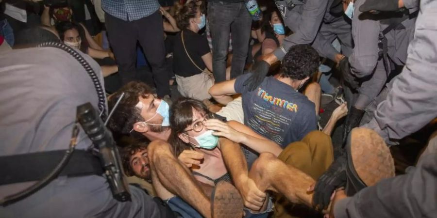 Israelische Polizeibeamte nehmen Demonstranten während eines Protests gegen Israels Premierminister Benjamin Netanjahu vor seiner Residenz in Jerusalem fest. Foto: Ariel Schalit/AP/dpa