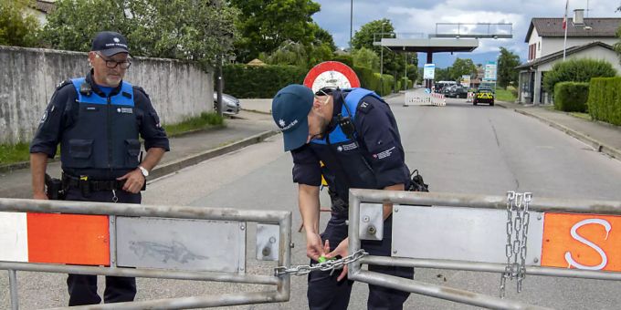 Beamte entfernen eine Absperrung bei der Grenze zu Frankreich. grenzen