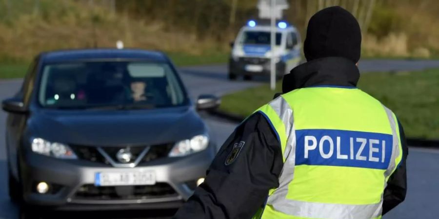 Ein Beamter der Bundespolizei steht an der deutsch-dänischen Grenze an einem Kontrollpunkt. Foto: Carsten Rehder/dpa