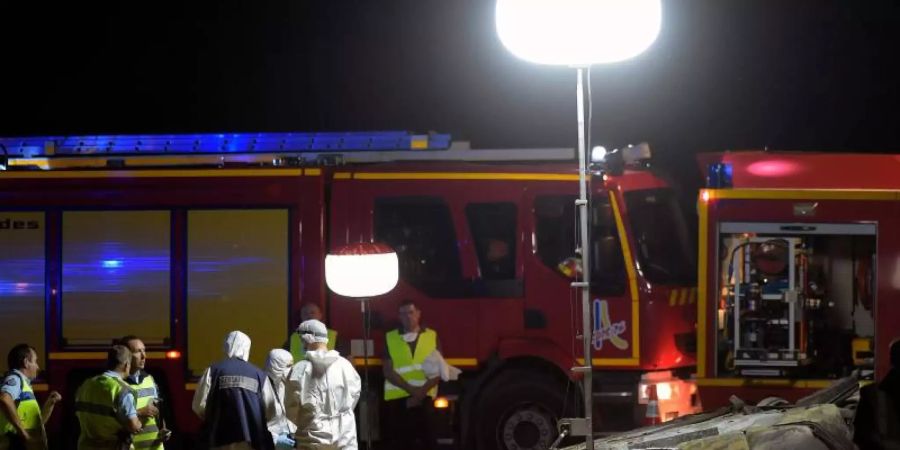 Retter und Feuerwehrleute an der Unfallstelle auf der Autobahn A7 bei Valence. Foto: Olivier Chassignole/AFP/dpa