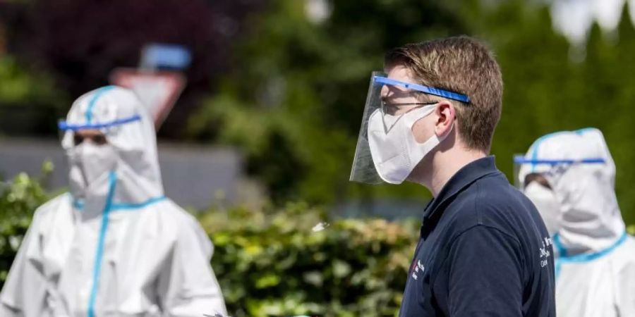 Helfer vom Deutschen Roten Kreuz im Einsatz: 40 mobile Testteams sind unterwegs, um Angestellte der Firma Tönnies zu Hause in ihrer Quarantäne aufzusuchen. Foto: David Inderlied/dpa