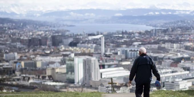 Ein Mann spaziert auf der Waid mit Blick in Richtung Stadt Zürich.