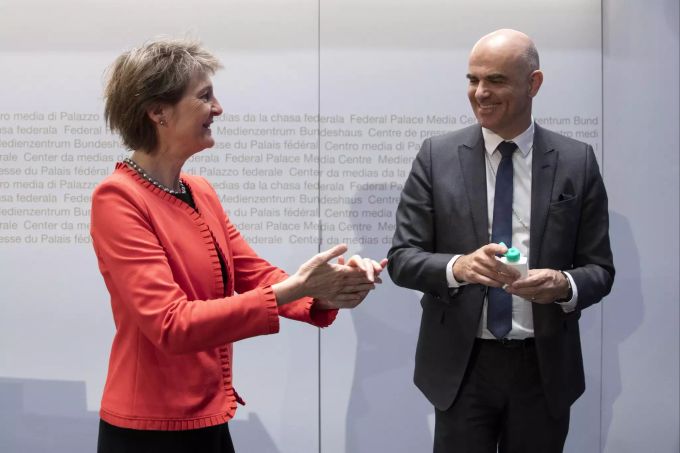 Simonetta Sommaruga und Alain Berset waschen sich nach einer Pressekonferenz mit Desinfektionsmittel die Hände. Coronavirus - Schweiz