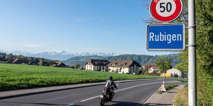 Ortstafel von Rubigen mit Motorradfahrer.