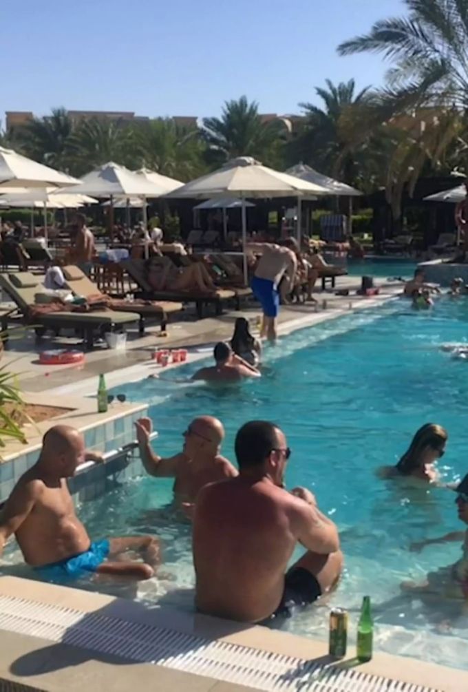 Gäste eines Hotels in der Nähe von Dubai entspannen sich am Pool. dubai hotel