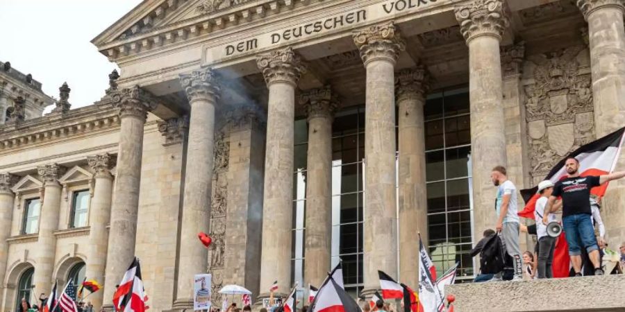 August 2020: Teilnehmer einer Kundgebung gegen die Corona-Massnahmen auf den Stufen zum Reichstagsgebäude. Foto: Achille Abboud/NurPhoto/dpa