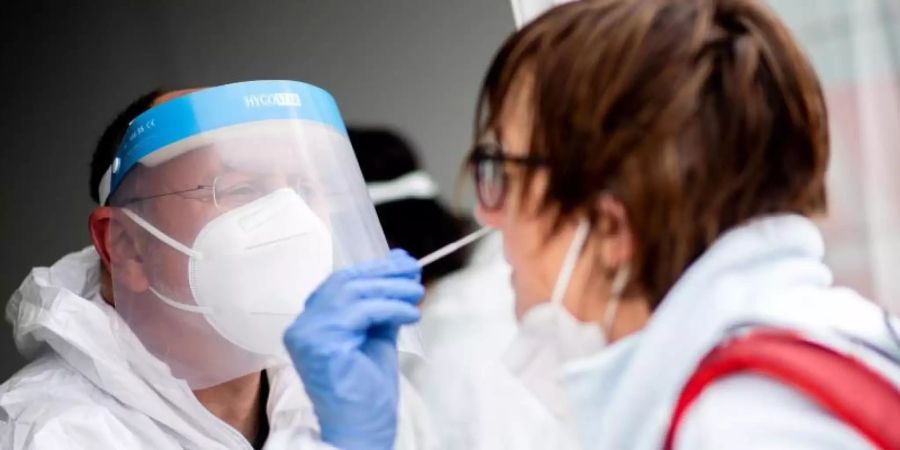 Ein Mitarbeiter eines Testcenters führt einen Test auf das Coronavirus durch.