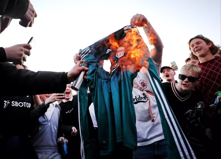 Fans verbrennen aus Protest gegen die Gründung einer europäischen Super League ein Trikot des FC Liverpool.