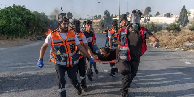 21.05.2021, Palästinensische Autonomiegebiete, Ramallah: Sanitäter evakuieren einen verletzten palästinensischen Demonstranten nach Zusammenstössen mit israelischen Soldaten am nördlichen Eingang von Ramallah. Konflikt in Nahost - Proteste