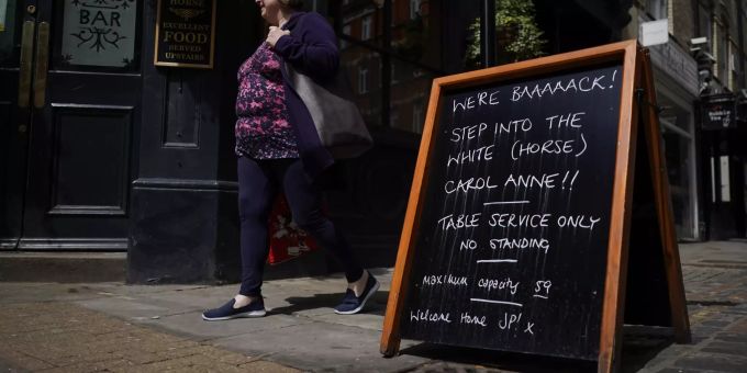 Eine Frau geht an einem Pub-Schild im Londoner Stadtteil Soho vorbei. (Symbolbild) Virus Outbreak Britain